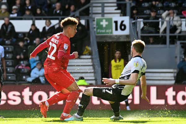 Henry Lawrence’s second-half strike earned Dons a point at Derby County on Easter Monday