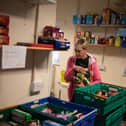 A worker at the Coventry Foodbank centre in Queens Road Baptist Church collates donated food items into parcels that will be provided to people arriving with a foodbank voucher.