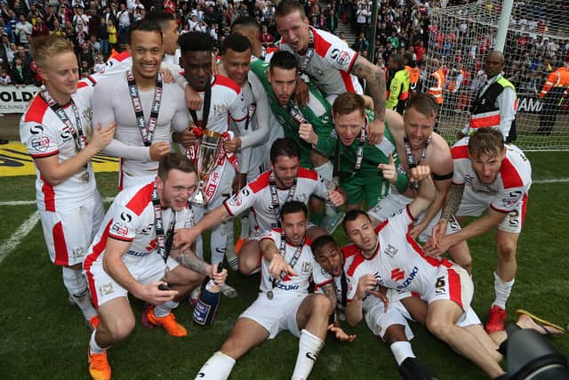 The MK Dons squad celebrate securing promotion on the final day of the 14/15 season
