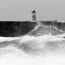 Waves crash over the breakwater by Newhaven Lighthouse as Storm Barra passes through Newhaven, southern England on December 7, 2021. (Photo by GLYN KIRK / AFP) (Photo by GLYN KIRK/AFP via Getty Images)