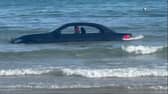 A convertable BMW was washed out to see after parking on a beach in Cornwall