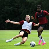 Cameron Norman slides in on Jonathan Leko in MK Dons pre-season training