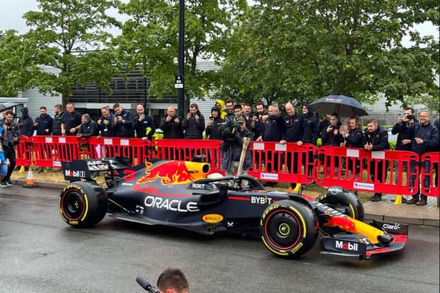 Daniel Ricciardo was behind the wheel of the Red Bull car, holding the Baton of Hope as he toured Milton Keynes. Pic: Fiona Copeland