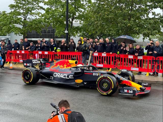 Daniel Ricciardo was behind the wheel of the Red Bull car, holding the Baton of Hope as he toured Milton Keynes. Pic: Fiona Copeland