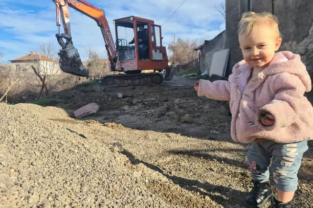 Fae by a digger being used to renovate the farmhouse.