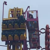 Horrified onlookers watched as rescuers scrambled to the aid of eight terrified people stuck “at the top” of a 22-metre rollercoaster.