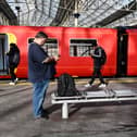 Commuters walk past a train stopped at a platform in Waterloo Station in London, during a national strike day, on February 1, 2023.