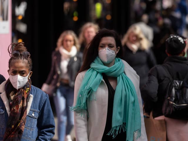 A woman wears a face mask while walking on Oxford Street.