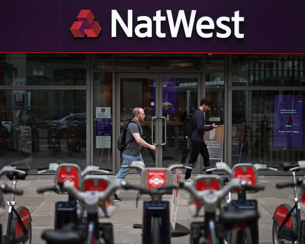 Pedestrians walk past a branch of a NatWest bank in London.