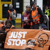 'Just Stop Oil' protesters block the road at the junction of Cannon St and Queen Victoria St on October 27, 2022 in London, England.