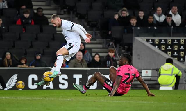 Stephen Wearne leapt the challenge of Shadrach Ogie to fire across for Alex Gilbey to put home MK Dons' second goal against Gillingham. Pic: Jane Russell