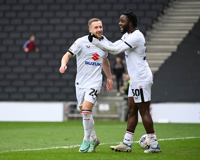 Matt Dennis celebrated with Stephen Wearne after the latter netted MK Dons' third goal against Crewe Alexandra