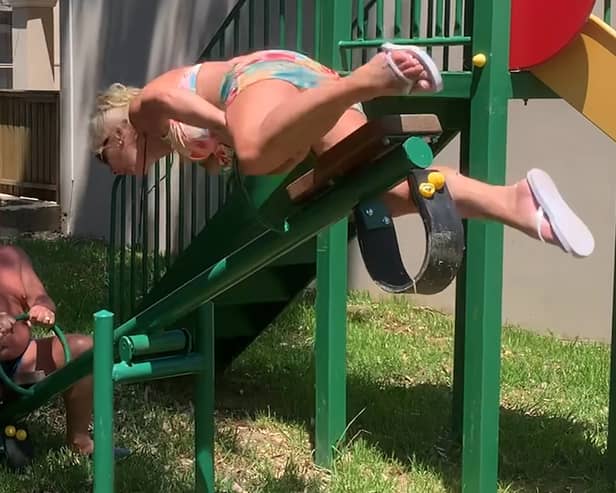 Grandmother flips over the handlebars of seesaw on holiday.