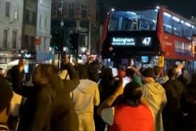 Excited England fans dance around “Bellingham” bus.