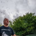 Gary Hough, 62, looks up to the skies outside his home surrounded in seagull