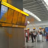 Just Stop Oil cover Heathrow Airport Terminal 5's departure boards in orange paint.