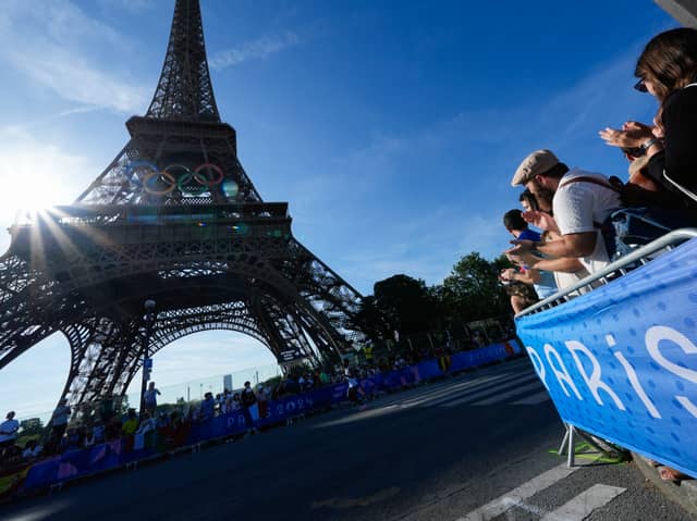 Spectators react as competitors run passed the Eiffel Tower during the Olympic Games Paris 2024. Photo: Rebecca Blackwell - Pool/Getty Images