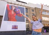 Ashley puts sweat shame to sweat fame by standing in front of her sweating billboard as the new face of Extra Flamin' Hot snacks