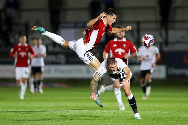 Callum Hendry takes a tumble during Dons' 1-0 defeat to Salford City