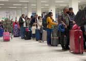 Passengers queue for check in at Manchester Airport's Terminal 1.