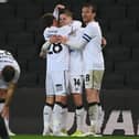 Tom Carroll and Alex Gilbey celebrate with goal-scorer Joe Tomlinson