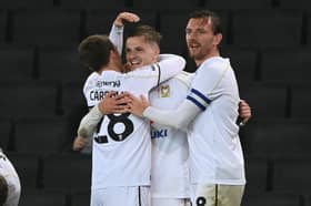 Tom Carroll and Alex Gilbey celebrate with goal-scorer Joe Tomlinson
