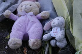 Flowers and stuffed toys are left as tributes to 'Baby A'.