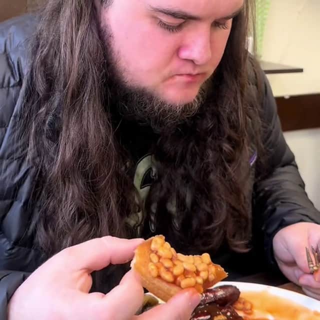 Kalani Smith reviewing a full English breakfast. British cafe goes viral after US TikToker gives glowing reviews of a full English breakfast.