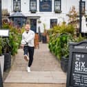 Former England rugby international Danny Care kicking a ball "into space" from outside the Greene King sport pub The Barmy Arms in Twickenham