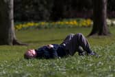 A man sleeps on the grass.