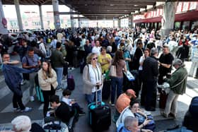 People wait outside the Atocha train station in Madrid after its closure as a massive power outage hits Spain.