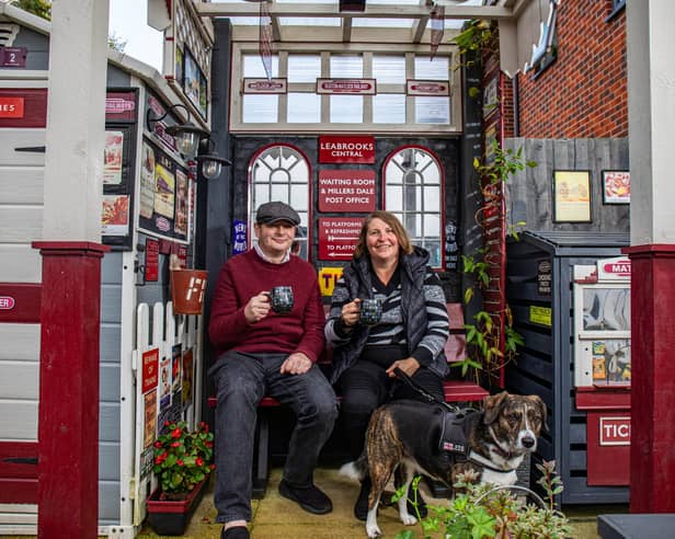 Train-mad couple Richard Cantrell and Katherine Siggins with dog Jess in the back garden at their home-made 'station'.