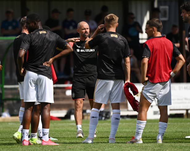Paul Warne speaks with his players during warm-up