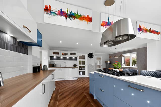 The expansive kitchen features contemporary fitted units, a central island and wide bi-fold doors to the garden.