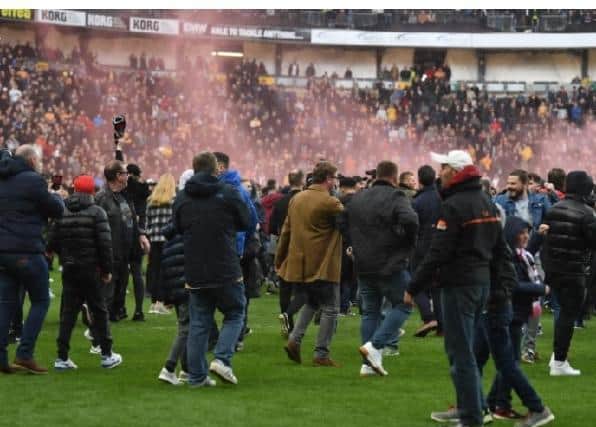 Fans invaded the pitch following Dons' promotion to League One