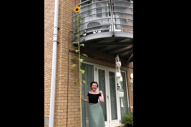 Emma next to her towering sunflower