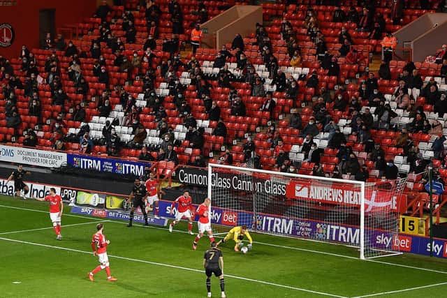 Charlton fans sitting socially distanced behind the goal at The Valley