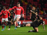 Ben Gladwin tackles former Dons team-mate Alex Gilbey at Charlton on Wednesday