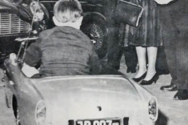 The young Prince Andrew tries out his scale model of  an Aston Martin 007 DB5 in Newport Pagnell