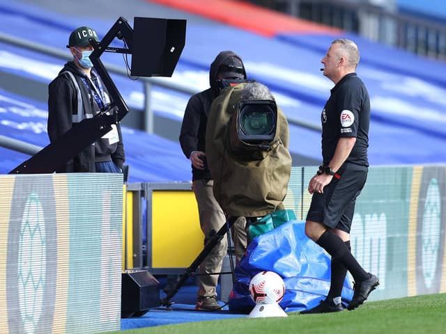 Referee Jonathan Moss checks an incident on the monitors