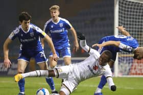Ethan Laird is closed down by three Gillingham players
