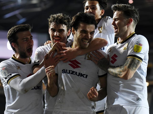 Dons celebrate Scott Fraser's late penalty to win the game