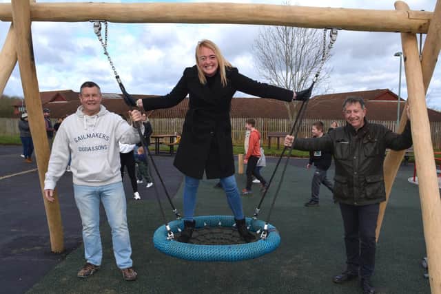Childminder Sam Simmons tries out the new play equipment with fellow campaigners