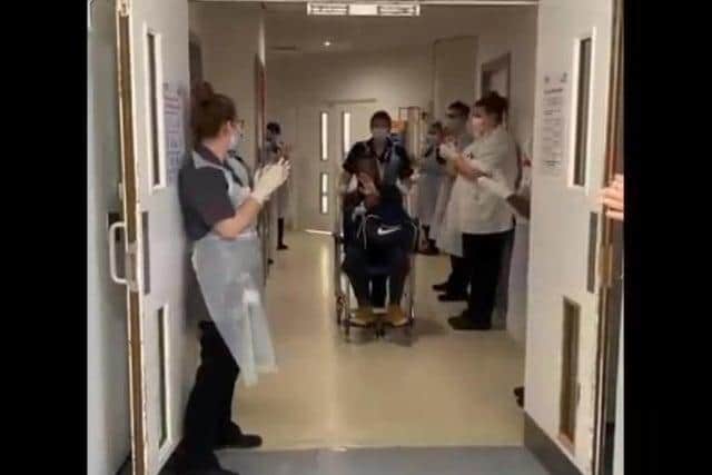 Nurses line the corridor to clap as a Covid patient leaves hospital