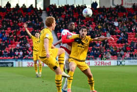 Dean Lewington and Joe Walsh in action at the Keepmoat Stadium