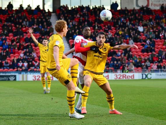 Dean Lewington and Joe Walsh in action at the Keepmoat Stadium