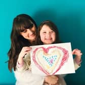 Lucy and her own daughter with a drawing about to be posted