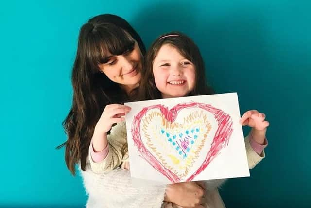 Lucy and her own daughter with a drawing about to be posted