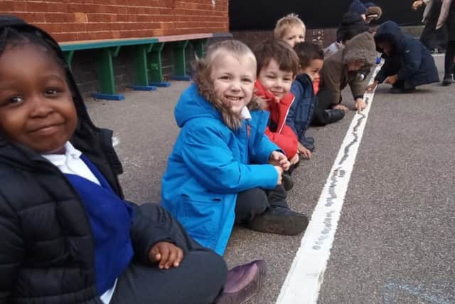 Pupils laying coins in to raise money for MK Hospital