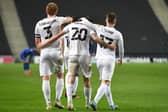 Dean Lewington and Dan Kemp celebrate with Troy Parrott